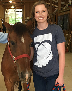 Liesel Jaeger-Agape poses with a horse at the Therapy Riding Center